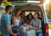 Groupe de famille et amis riant en chargeant le coffre du van